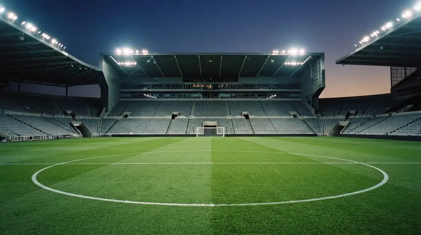 Een leeg voetbalstadion met lichtmasten bij schemering