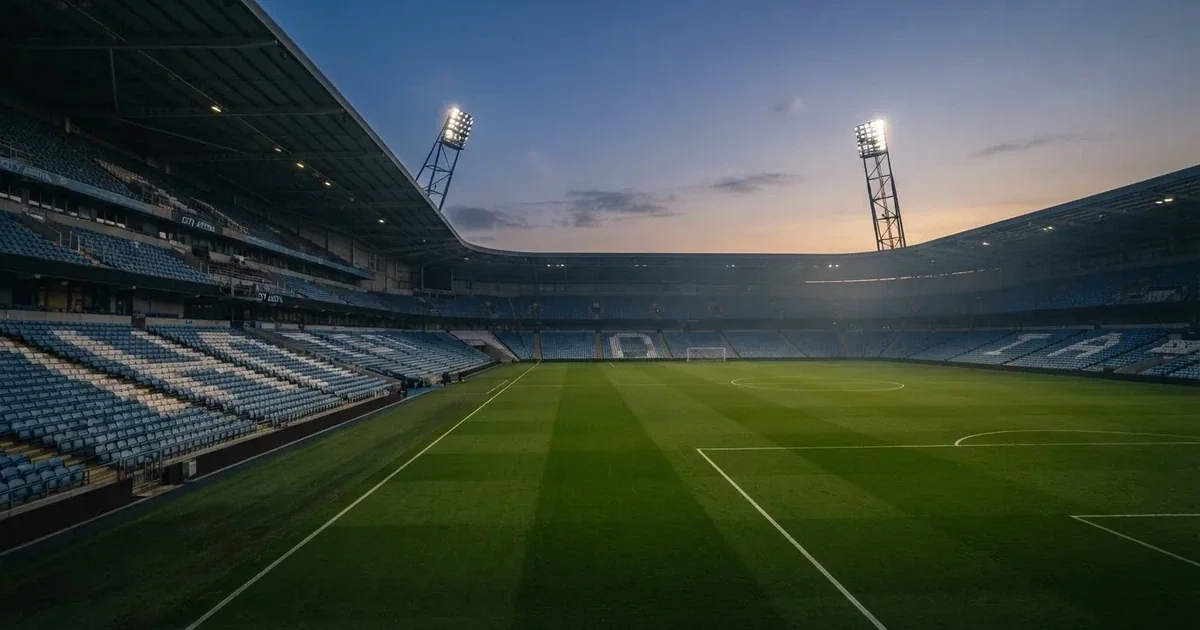 Een leeg voetbalstadion met lichtmasten bij schemering